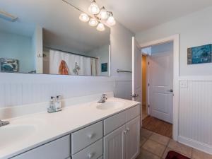 a bathroom with a sink and a mirror at Sand By Me in Surf City