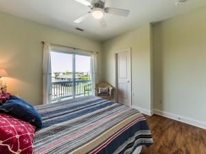 a bedroom with a bed and a window with a balcony at Sand By Me in Surf City +45 photos