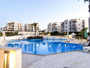 Bazén v ubytování amwaj chalet north coast قرية أمواج الساحل الشمالي nebo v jeho okolí