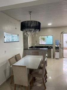 una sala da pranzo con tavolo e sedie bianchi di Casa - período do festival a Parintins