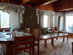 a living room with a table and chairs and a couch at Available for Kalam in Kalām