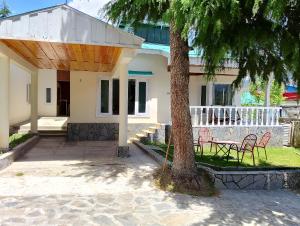 a house with a tree and a table and chairs at Available for Kalam in Kalām