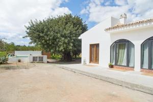 una casa blanca con un árbol en el fondo en Finca La Madreselva, en Alhaurín el Grande