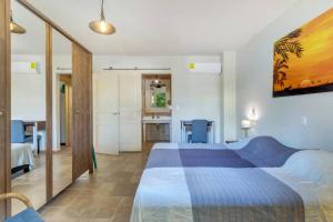 a bedroom with a large bed and a kitchen at Ocean Breeze Apartments #33 in Kralendijk