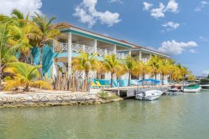 a resort with palm trees and boats in the water at Ocean Breeze Apartments #33 in Kralendijk