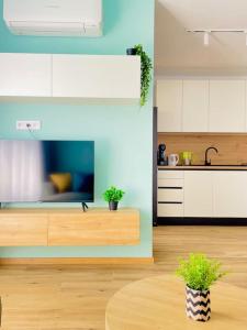 a kitchen with white cabinets and a table with plants at Designer luxury apartment 1BDR in Sofia