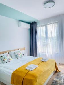 a bedroom with a large bed with a yellow blanket on it at Designer luxury apartment 1BDR in Sofia
