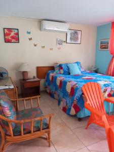 a bedroom with a bed and a chair at Seacastle Deluxe Studio in Montego Bay