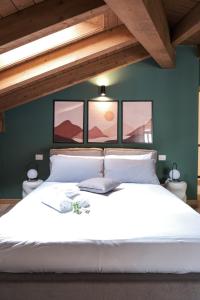 a bedroom with a white bed with three pictures on the wall at CharmEscape OldTown - 6 min walk to BerninaExpress in Tirano +31 photos