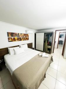 um quarto com uma cama grande e um espelho grande em Blue Sunset Beira Mar em João Pessoa