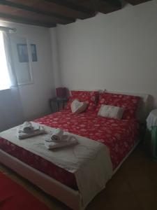 a bedroom with a red bed with towels on it at La DOGARESSA in Porto Viro