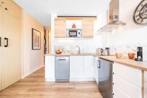 a kitchen with white cabinets and a counter top at BeachSide Maspalomas FKK friendly in Maspalomas
