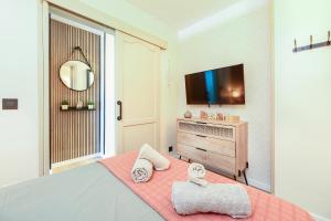 a bedroom with a bed with a tv and a mirror at BeachSide Maspalomas FKK friendly in Maspalomas +18 photos
