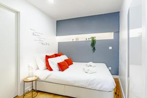 una camera da letto con un letto bianco con cuscini rossi di Visit Lisbon4fun - Alfama a Lisbona