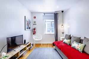 un soggiorno con divano rosso e TV a schermo piatto di Visit Lisbon4fun - Alfama a Lisbona