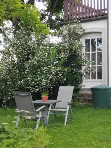 twee stoelen en een tafel voor een huis bij Ferienwohnung Linde bei Ferienwohnungen May in Plankenfels