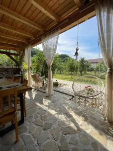 a patio with a table and a swing at Cuibul din livadă in Suduleni