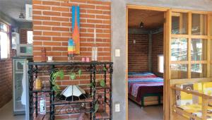 a room with a brick wall and a room with a table at Acogedor Bungalow en medio del bosque de Tepoztlan in Tlacotenco
