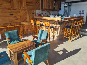 a kitchen with chairs and a table and a bar at Drinsko selo Ovčinja in Ovčinja