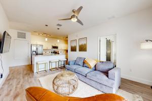 a living room with a blue couch and a kitchen at 2 Mi to UF Campus! Dog-Friendly Condo w/ Pool in West Hills