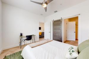 a white bedroom with a bed and a desk at 2 Mi to UF Campus! Dog-Friendly Condo w/ Pool in West Hills +23 photos