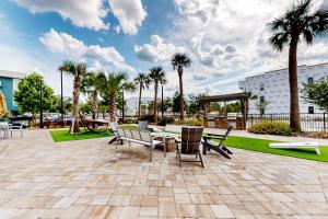 a patio with a table and chairs and palm trees at 2 Mi to UF Campus! Dog-Friendly Condo w/ Pool in West Hills