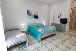 a bedroom with two twin beds and a television at Veranda sul Verde in Ficarazzi
