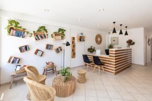a lobby with chairs and a counter with plants at Estudios Salinas - Fuseta in Fuzeta