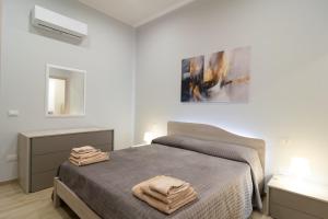 a bedroom with a bed with two towels on it at Veranda sul Verde in Ficarazzi