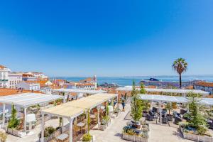 una vista di una città con ombrelloni bianchi e l'oceano di Visit Lisbon4fun - Alfama a Lisbona