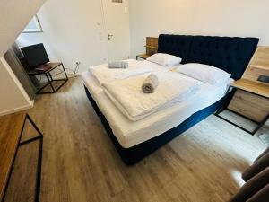 シュトゥットガルトにあるCity Suitesのベッドルームに大型ベッド1台(青いヘッドボード付) +1枚の写真