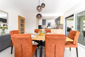 a kitchen and dining room with a wooden table and chairs at Villa Mihojka in Malinska +48 photos