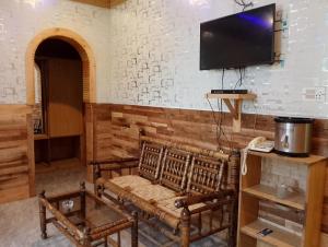 a living room with a couch and a flat screen tv at Eagle Nest Cottage, Kalam in Kalām
