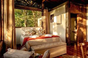 a bedroom with a bed and a window at Fabulosa Villa dos Chalés em Campos do Jordão in Campos do Jordão +125 photos