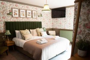 a bedroom with a large bed with towels on it at Bulls Head, Castleton in Castleton