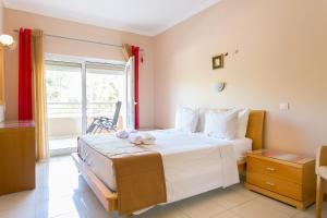 een slaapkamer met een groot bed en een raam bij Quinta da Barracuda by Golden Zenith in Albufeira +51 foto's
