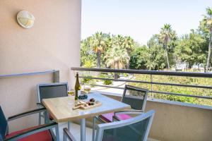 een tafel en stoelen op een balkon met een fles wijn bij Quinta da Barracuda by Golden Zenith in Albufeira