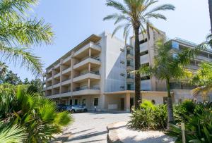 een gebouw met palmbomen ervoor bij Quinta da Barracuda by Golden Zenith in Albufeira