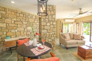 a living room with a table and a stone wall at Executive 1 Bedroom Poolside Apt Kilele suite in Christiansted