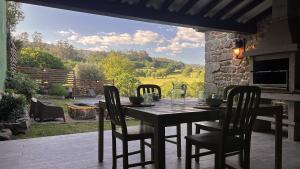 a table and chairs on a patio with a view at Cozy Galician Stone Farmhouse with Pool in Santo Tomé