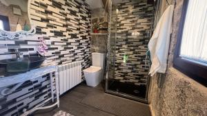 a bathroom with a shower with a sink and a toilet at Cozy Galician Stone Farmhouse with Pool in Santo Tomé +12 photos