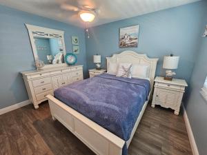 a bedroom with a bed and two dressers and a mirror at El Palmar Cottages LLC Whole House in Clearwater Beach