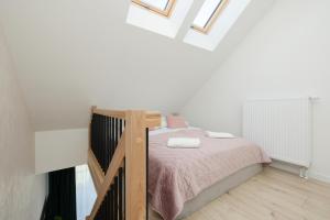 a small bedroom with a bed and a staircase at Apartament dwupoziomowy 17 in Rewal