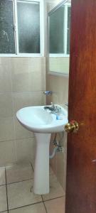 a bathroom with a white sink and a window at Hoteles Santa Regina in Chihuahua