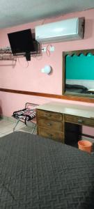 a bedroom with a desk and a mirror at Hoteles Santa Regina in Chihuahua