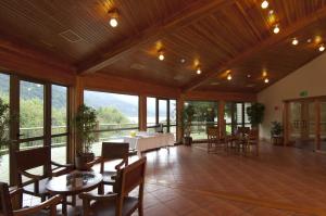 a large room with tables and chairs and windows at Loberias Del Sur in Puerto Chacabuco