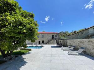 a group of lounge chairs sitting next to a building at Casa Curto in Terras de Bouro