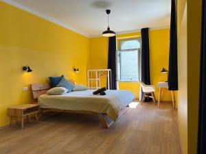 洛迦诺Villa Belforte的黄色卧室配有床和书桌