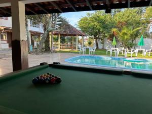 a pool table in front of a swimming pool at Hotel e Pousada Recanto do mar in Florianópolis