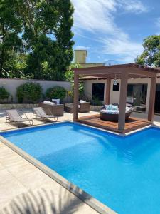 a swimming pool with a deck and a gazebo at Casa Amaral 3 in São Pedro da Aldeia